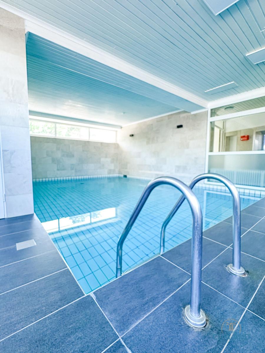 Innenpool mit Metalltreppe und blauen Fliesen