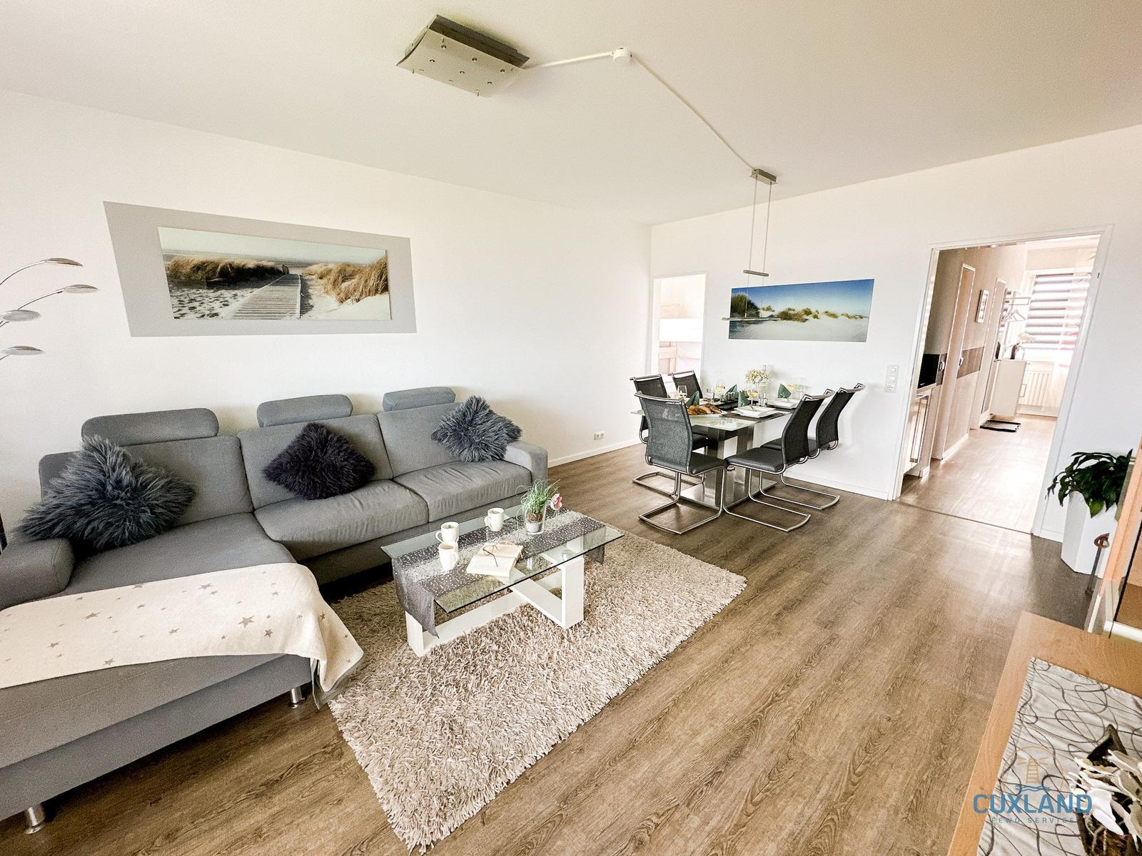 Wohn- und Essbereich mit Sofa, Esstisch und Holzboden.