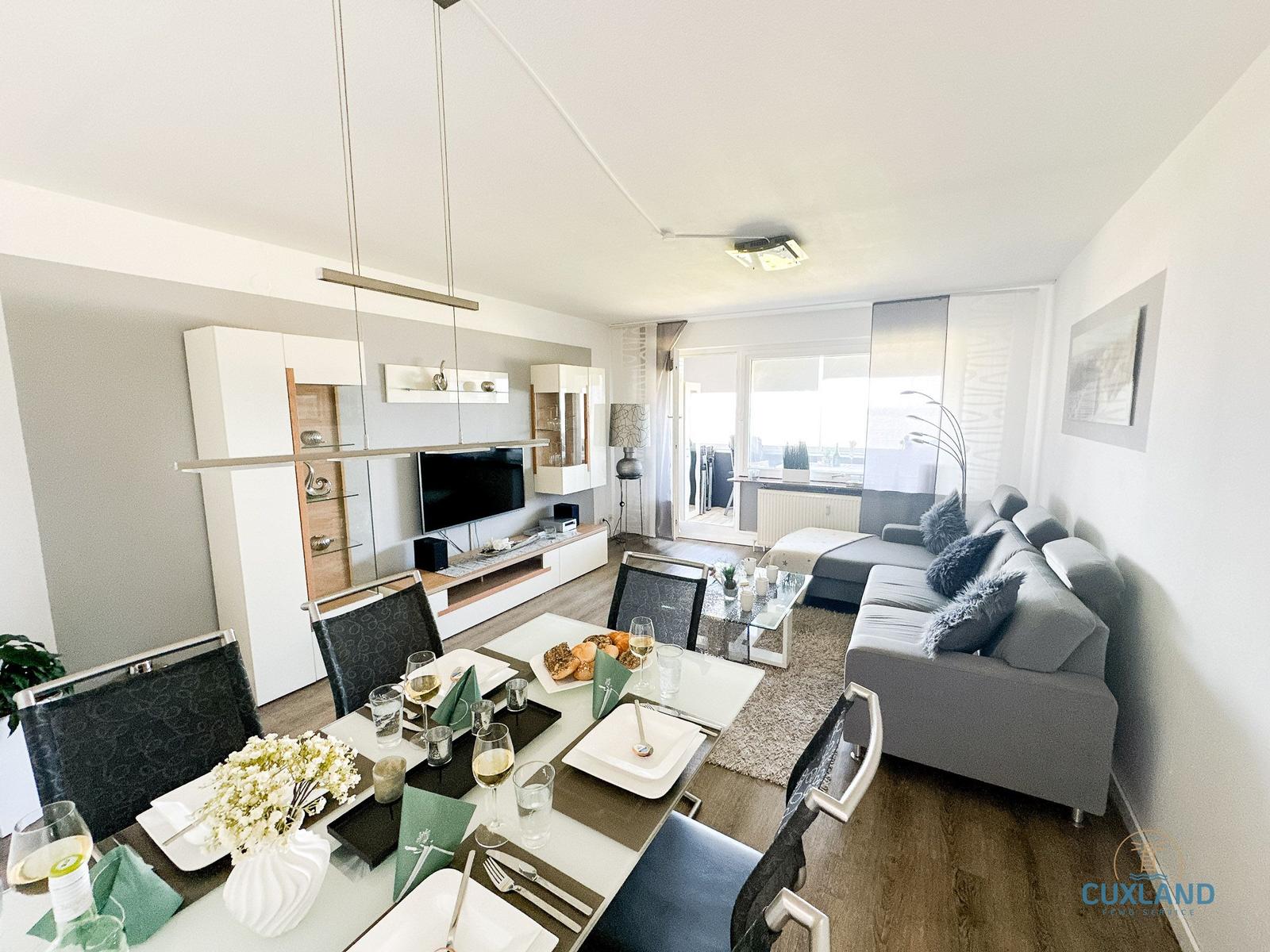 Wohn- und Essbereich mit Sofa, Esstisch und Fernseher. Terrasse mit Blick.