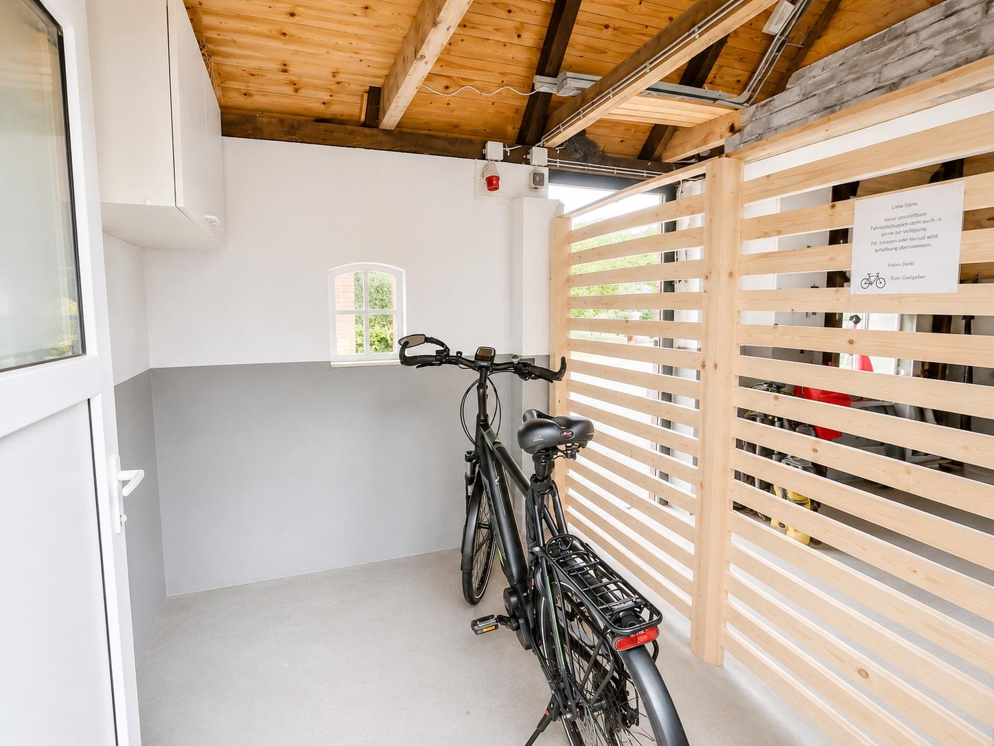 Ein Fahrrad steht in einem Raum mit Holzdecke und Holzgeländer.
