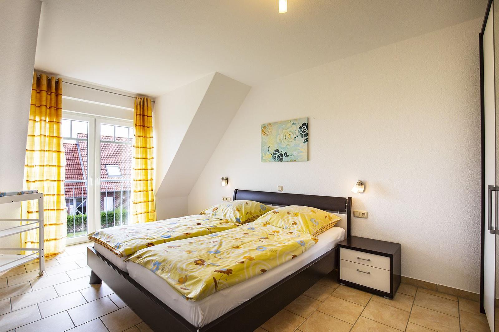 Schlafzimmer mit Doppelbett, Fenster und Nachttisch