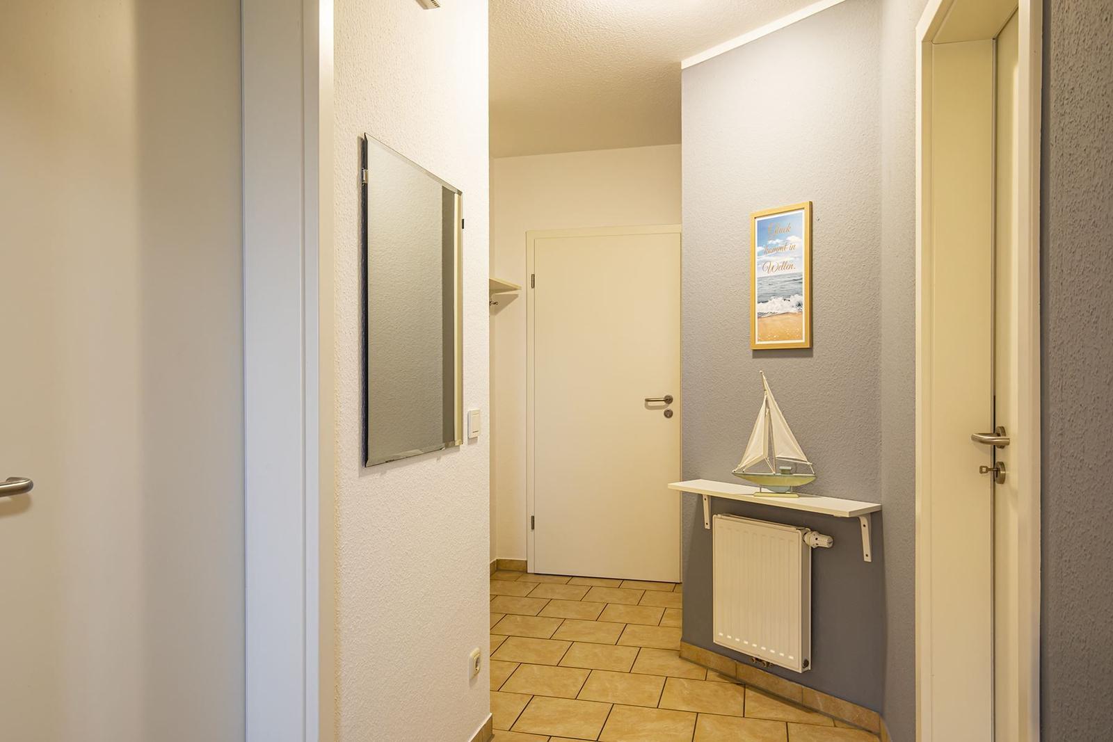 Flur mit Spiegel, Wandbild und Segelschiffmodell auf Schalter