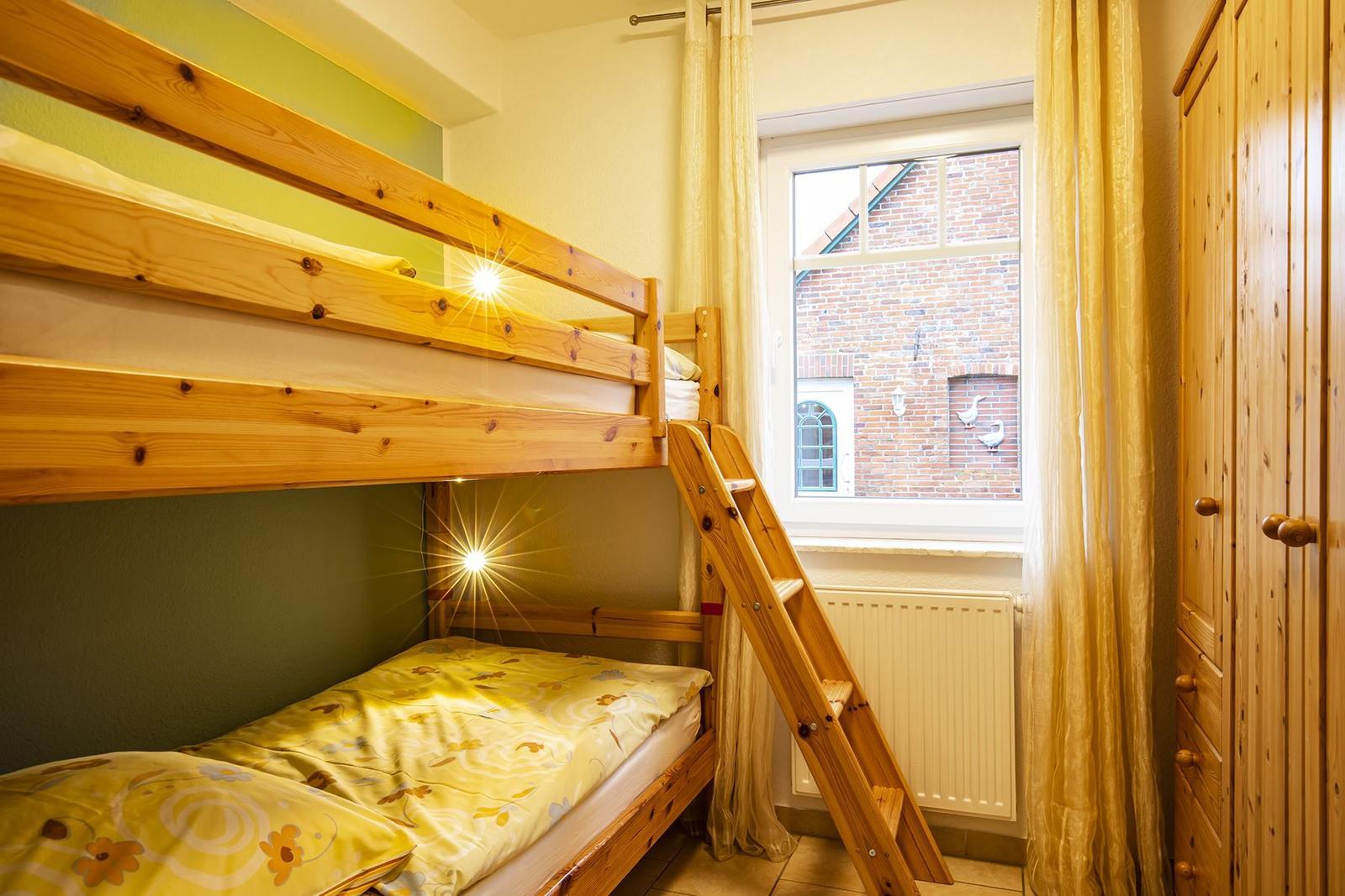 Zimmer mit Holzbett, Fenster und Kleiderschrank