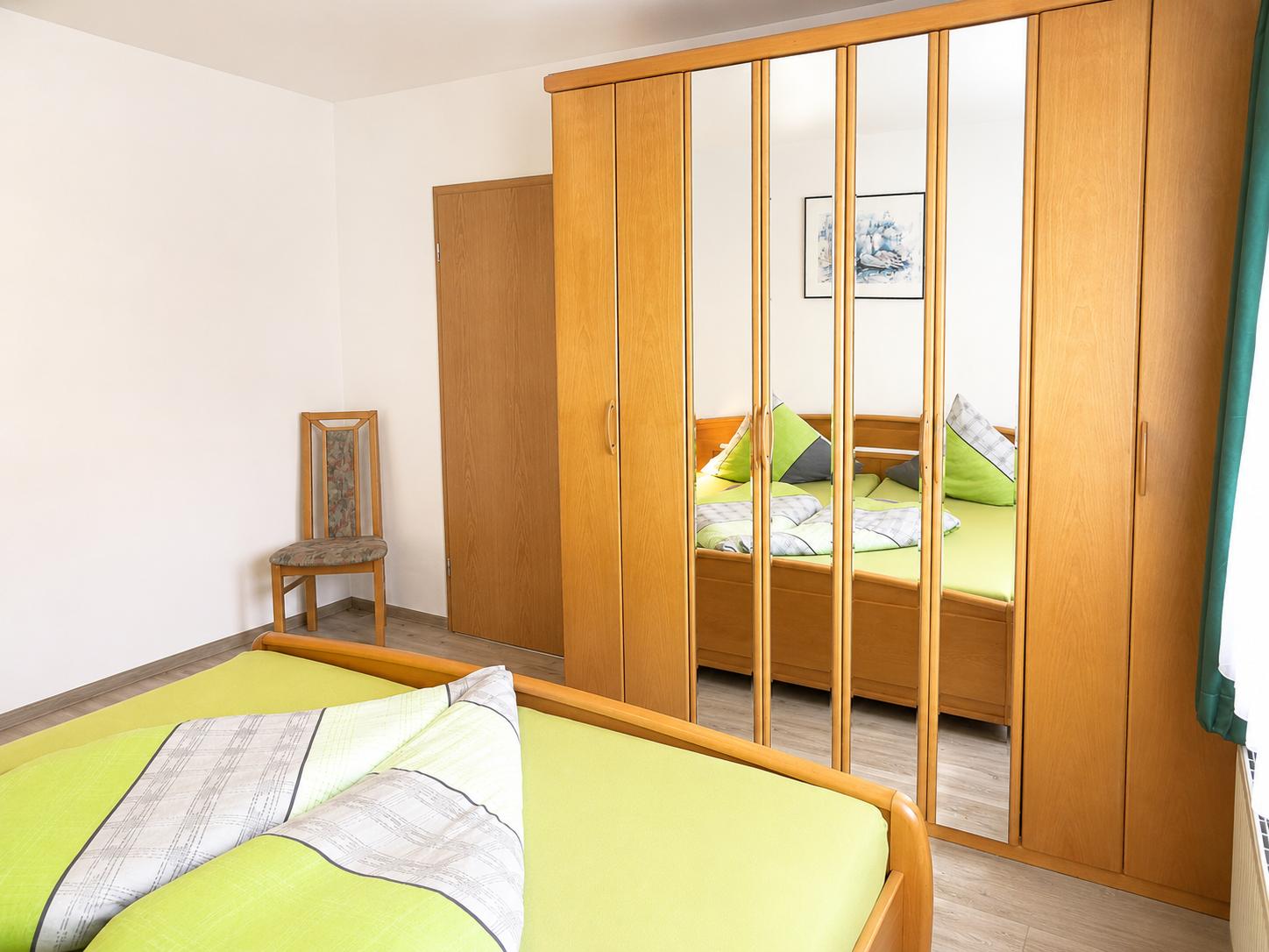 Elternschlafzimmer mit Blick auf großen Kleiderschrank mit Spiegel...
