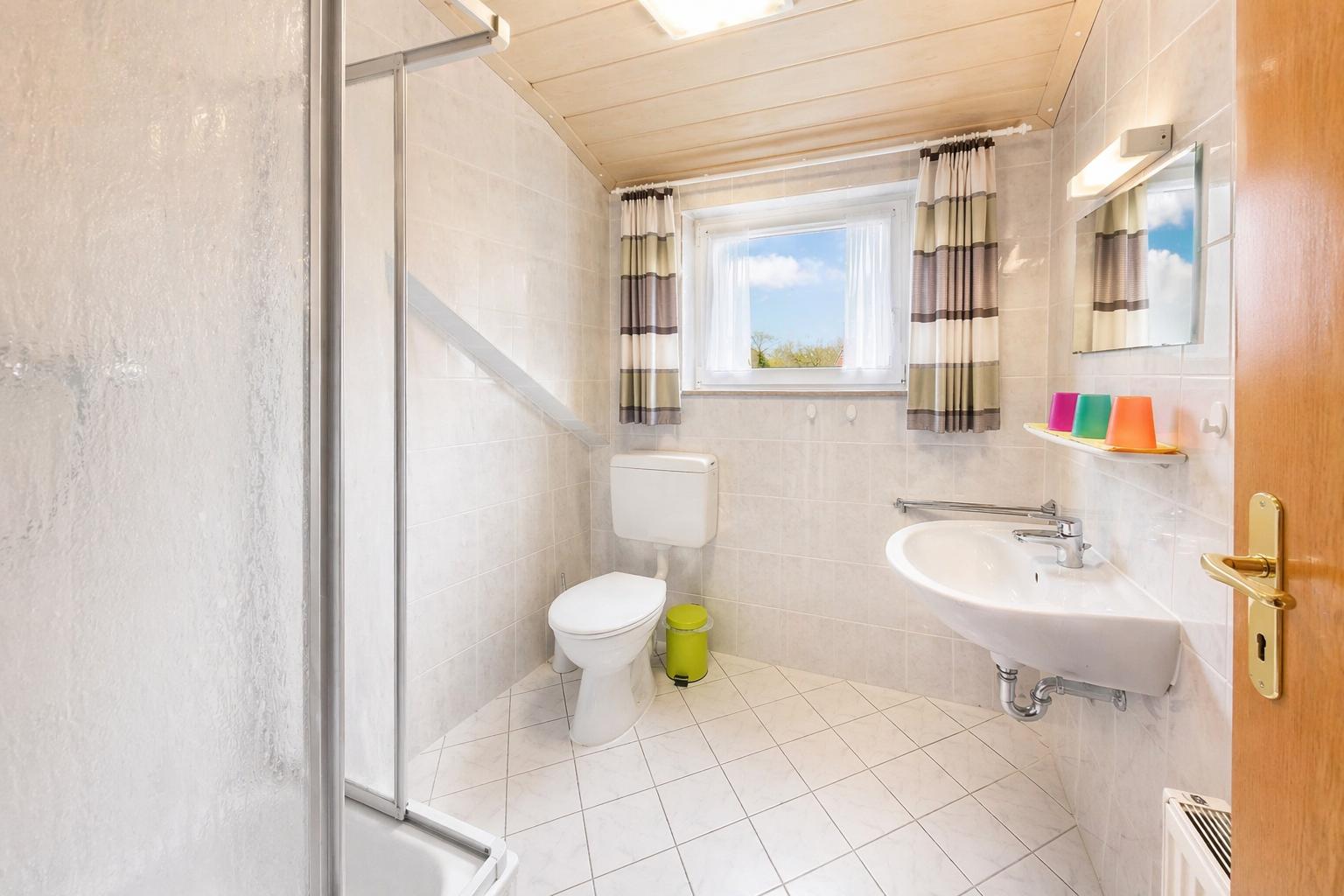 Badezimmer mit Dusche, Waschtisch und Toilette...