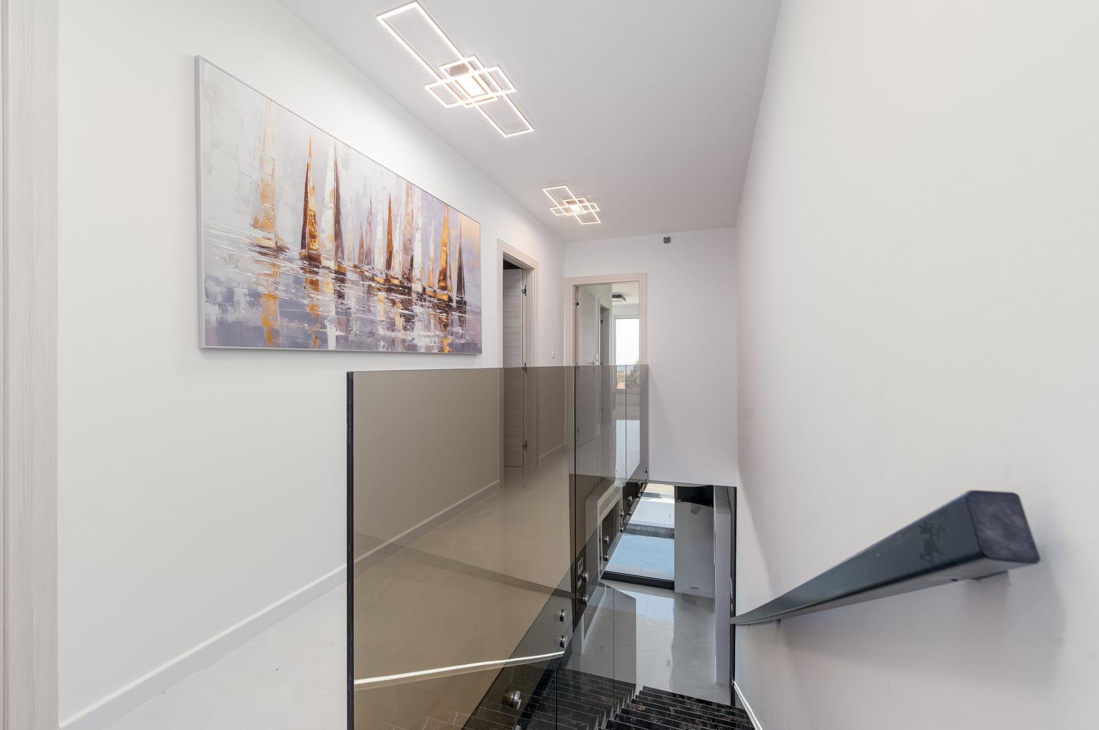 Höhenlage mit Glasgeländer und Wandbild an der Wand.