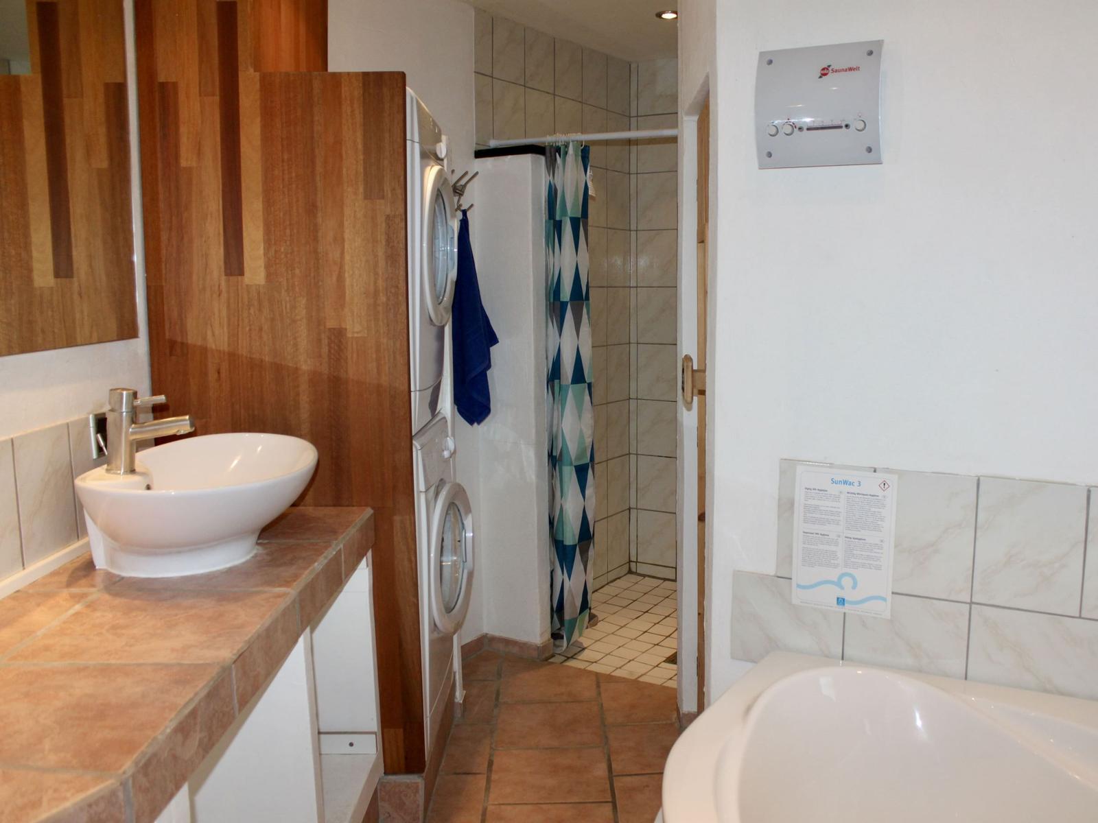Bad mit Waschmaschine, Dusche und Badewanne.