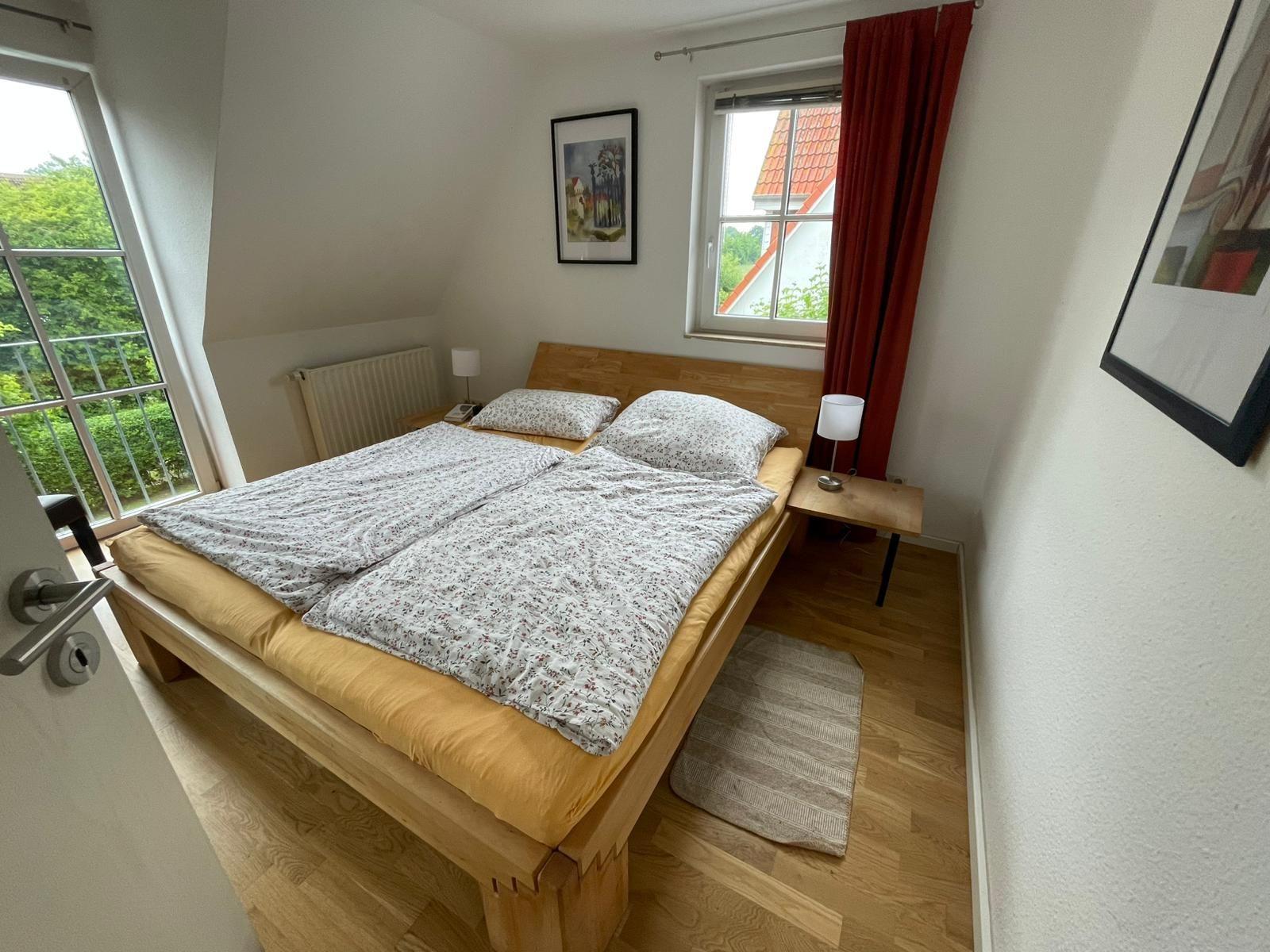 Schlafzimmer mit Doppelbett, Fenster und Holzboden