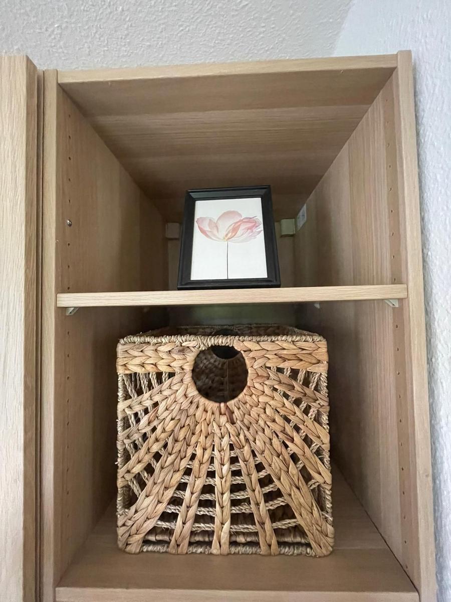 Holzregal mit Korb und Bild einer Blume