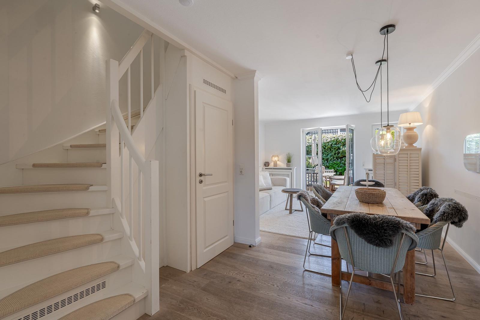 Haus mit Essbereich, Treppe und Blick in Wohnzimmer.