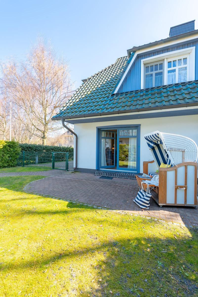 Haus mit Terrasse, Garten und Strandkorb. Tür zum Innenraum.