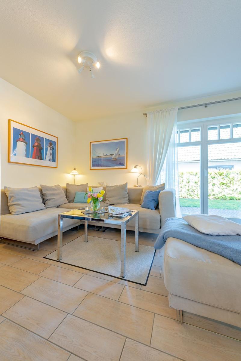 Wohnzimmer mit Sofa, Couchtisch und Fenster zur Außenansicht.