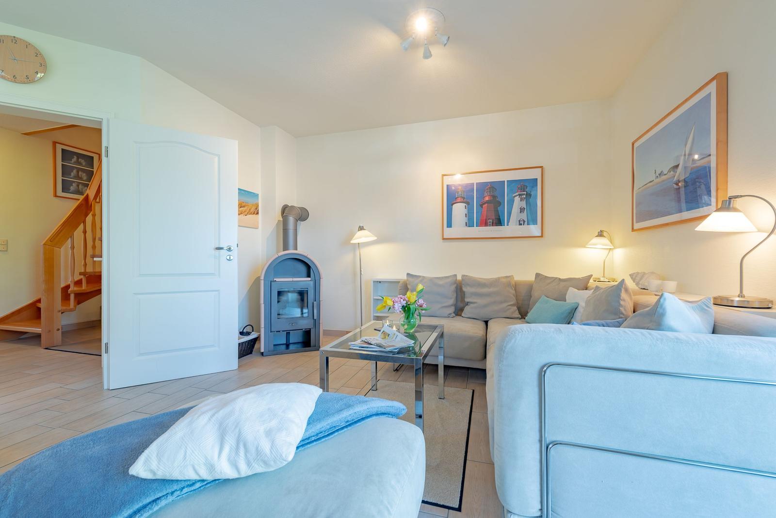 Wohnzimmer mit Sofa, Kamin und Wandbildern