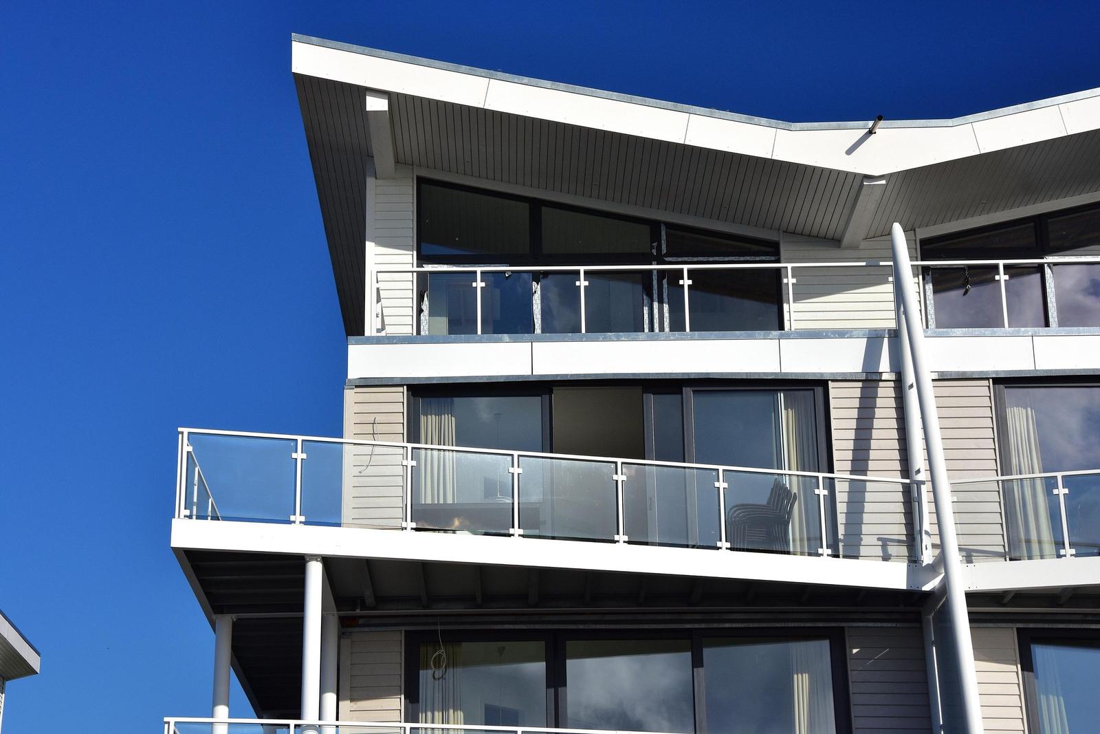 Moderne Wohnung mit Balkon und großen Fenstern unter blauem Himmel