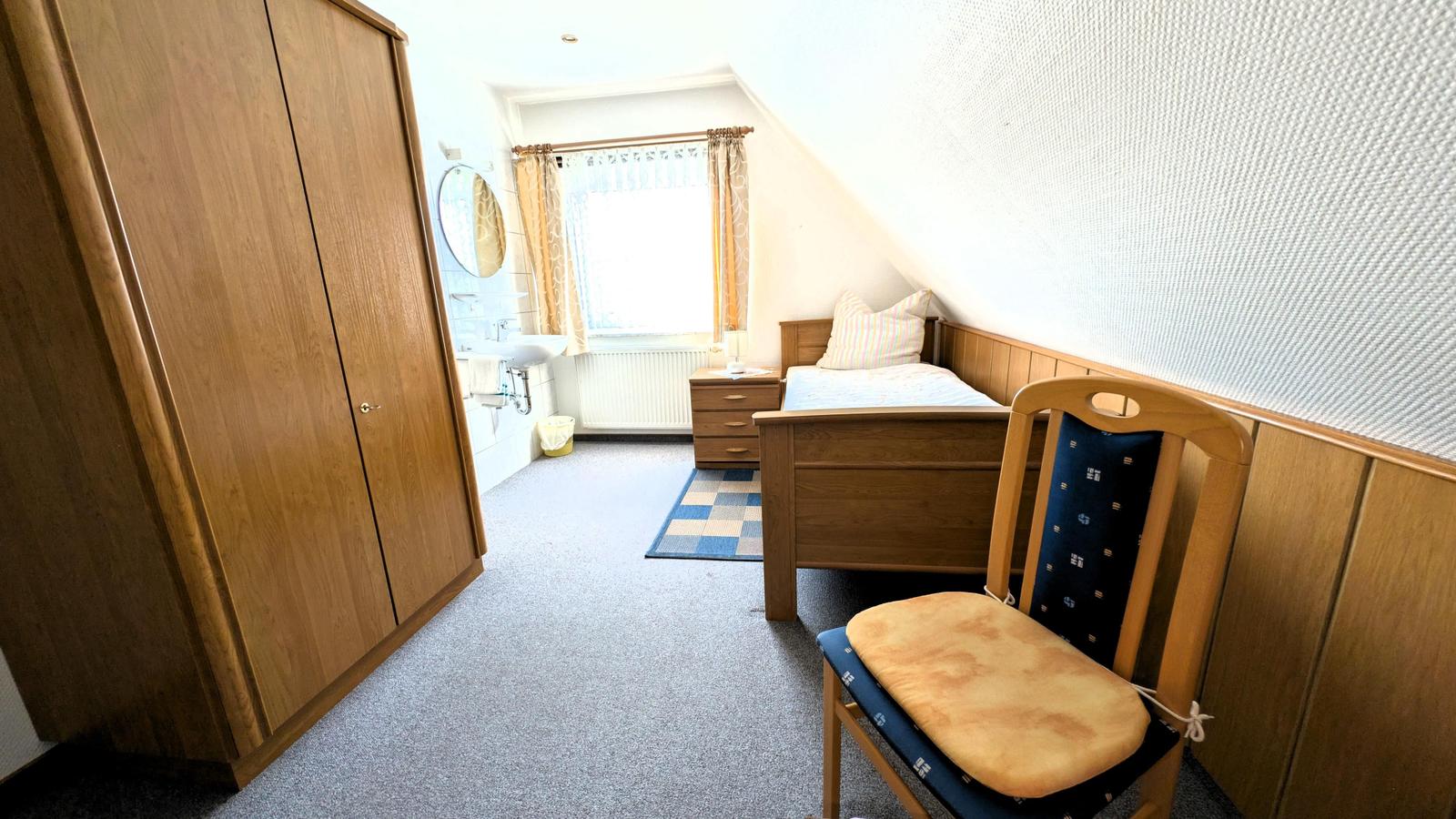 Schlafzimmer mit Bett, Kleiderschrank und Bad im Anschluss