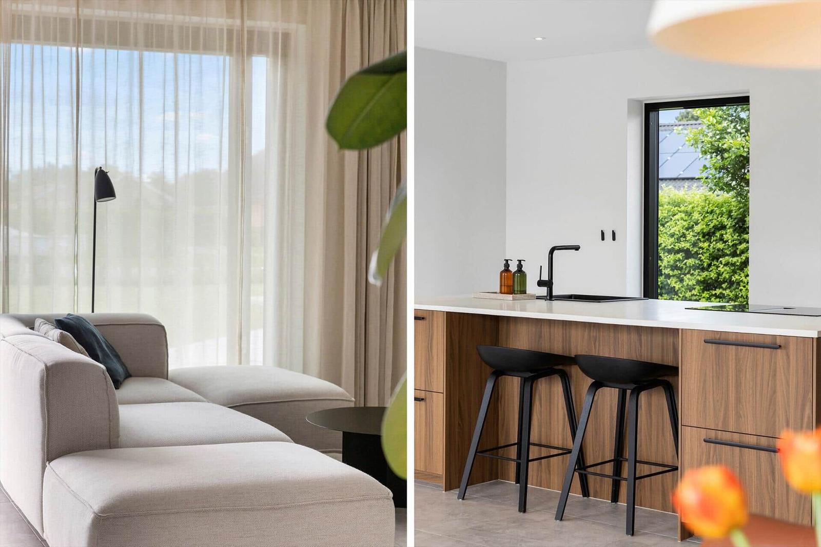 Wohnzimmer mit Sofa und Fenster. Küche mit Barhocker und Fenster.