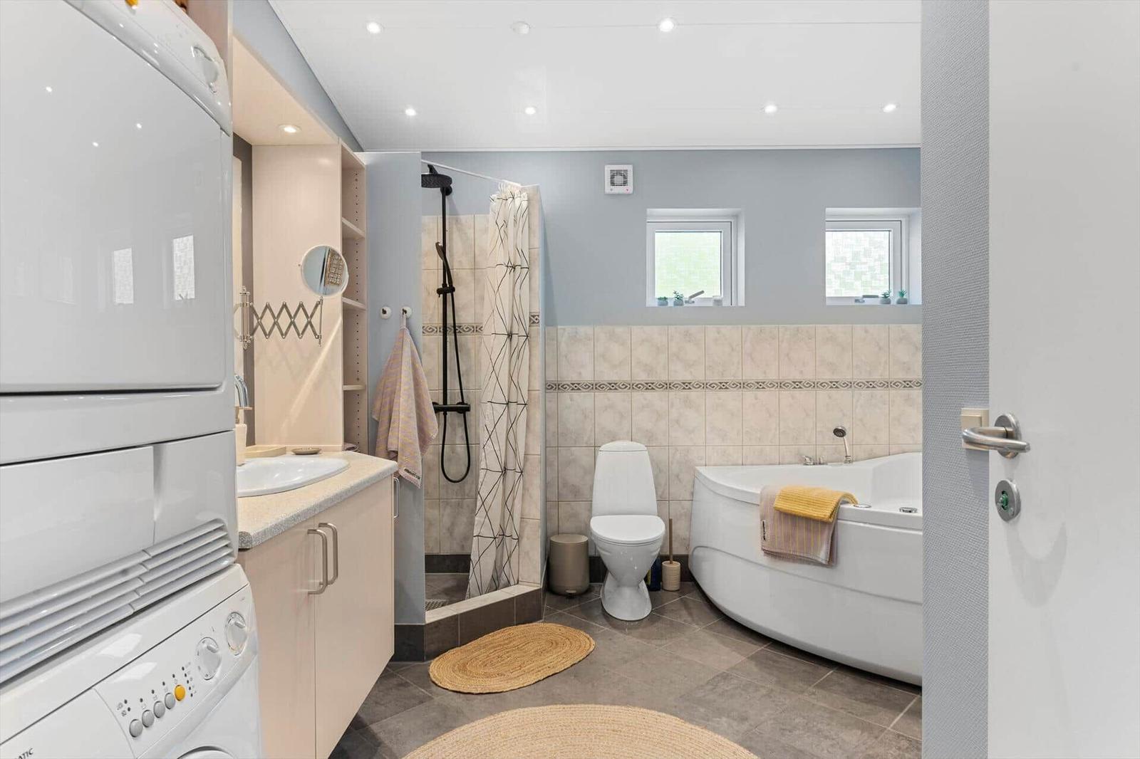 Bathroom with shower, bathtub, toilet, and washing machine