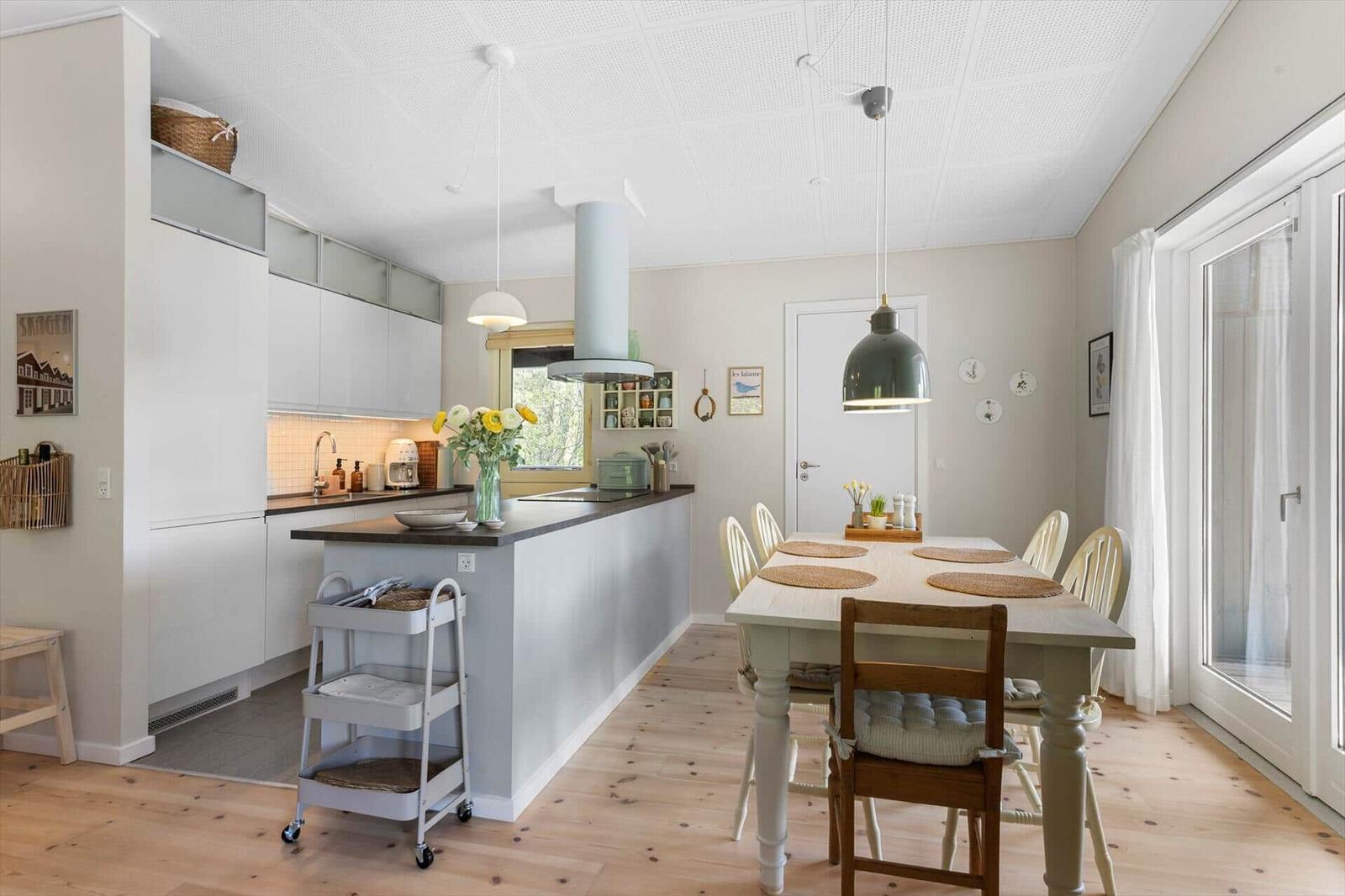 Kitchen with dining area, wooden floor, and window to the outside.