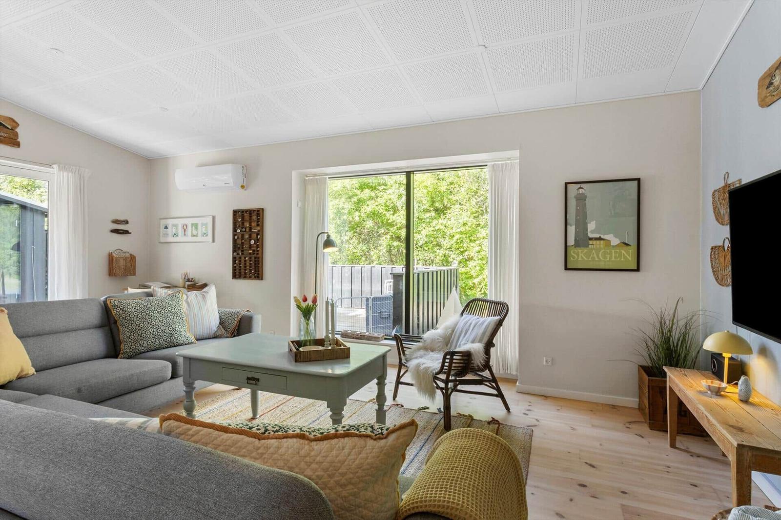 Living room with sofa, coffee table, and view of balcony