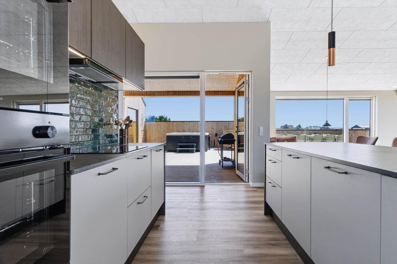 Moderne Küche mit Blick auf Terrasse und Whirlpool.