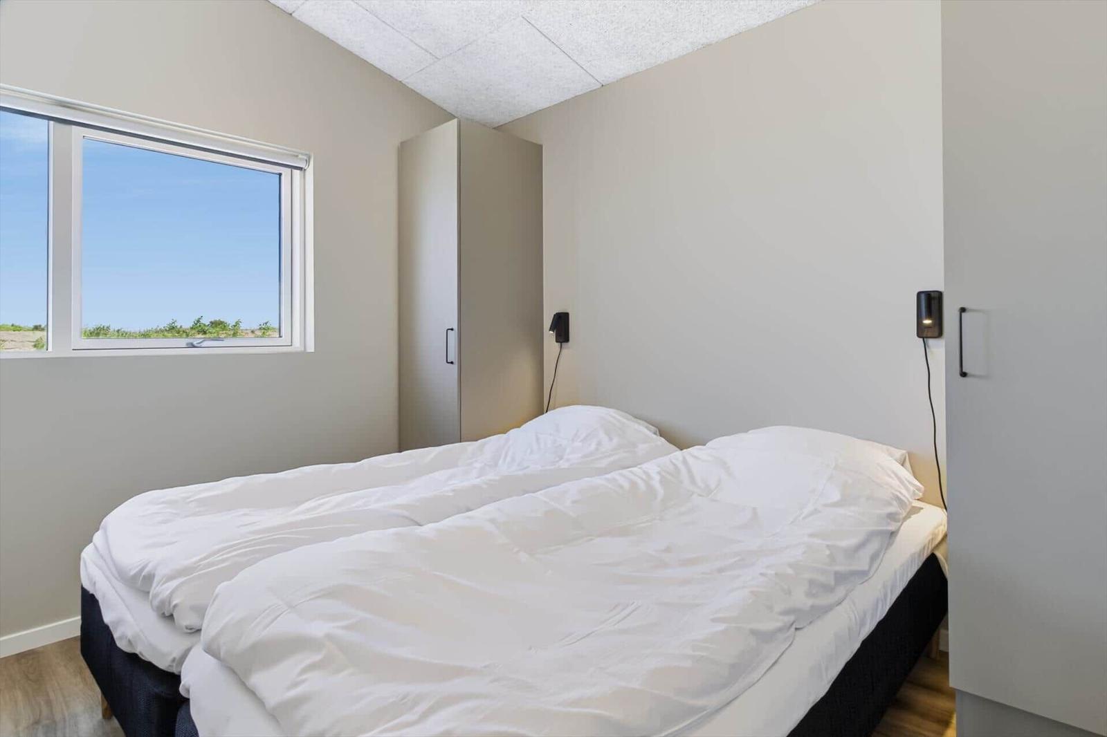 Schlafzimmer mit Bett, Fenster und Schränken