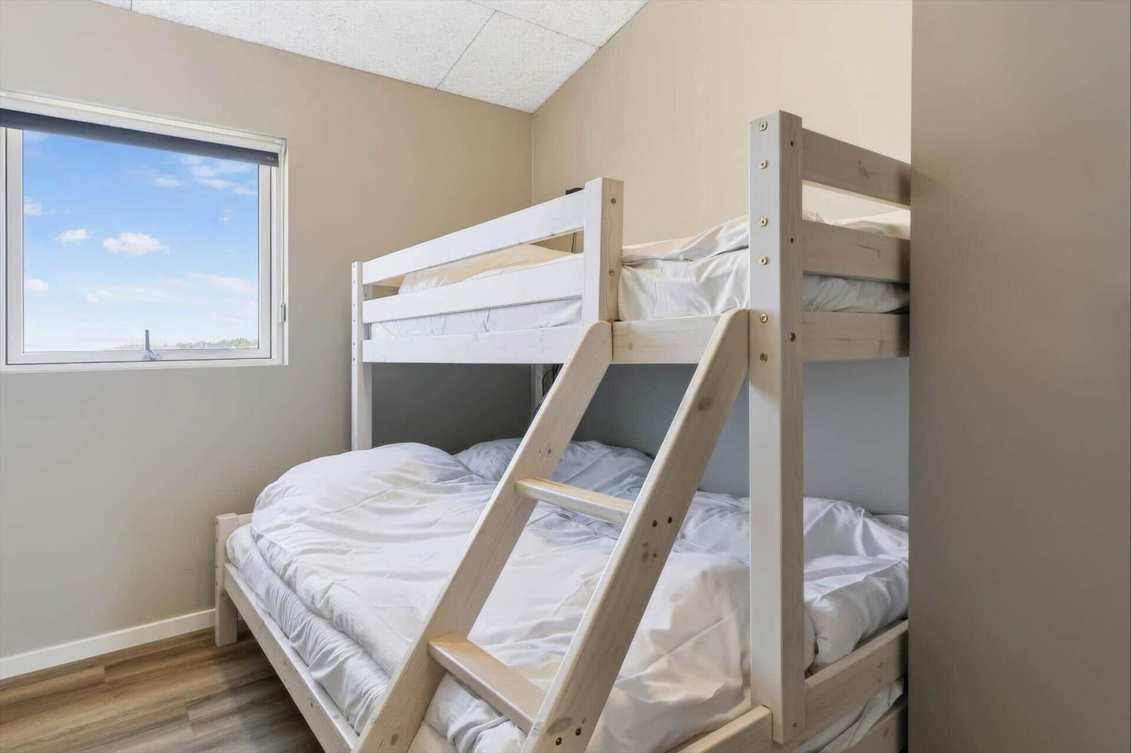 Zimmer mit Doppelstockbett und Fenster mit Blick nach draußen.