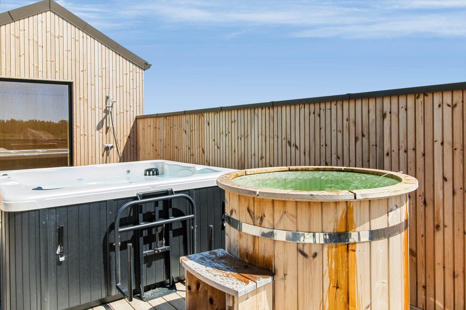 Außenbereich mit Whirlpool und Holzbadewanne auf Terrasse.