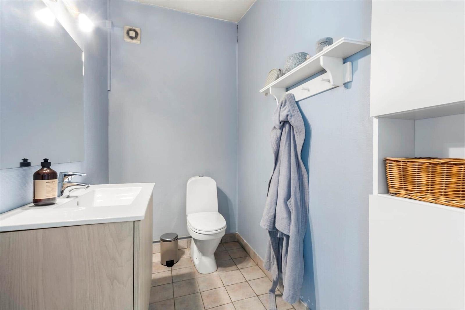 Badezimmer mit Waschbecken, Toilette und Handtuchhalter.