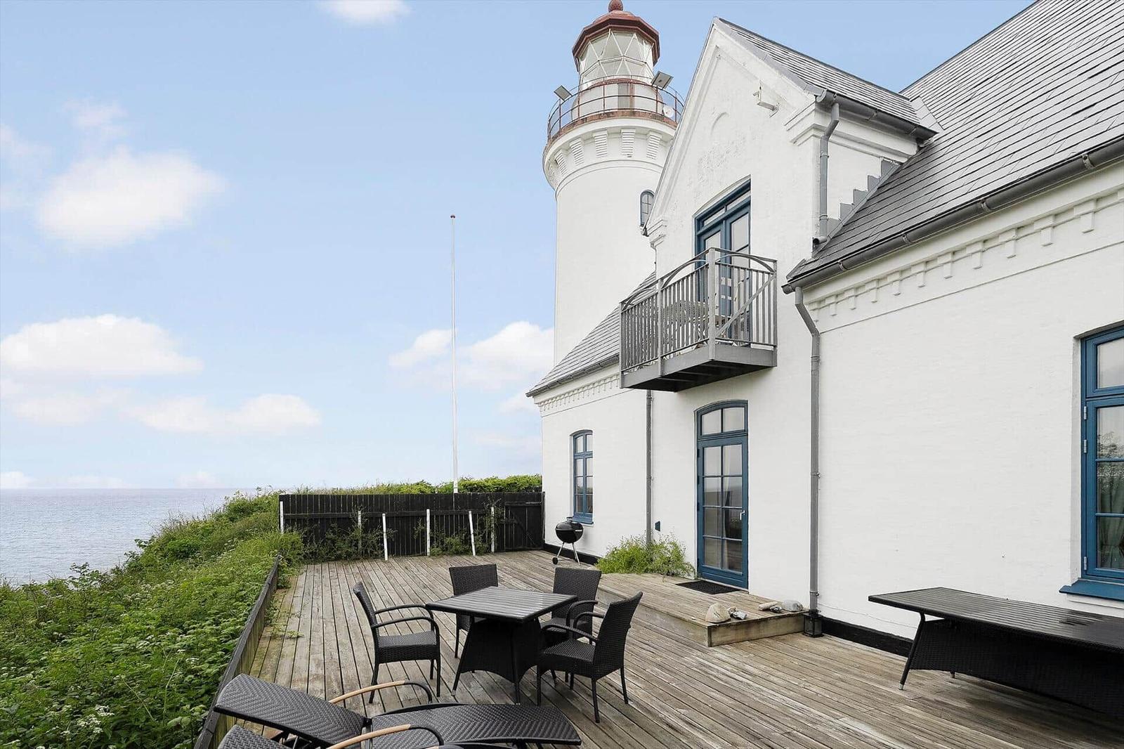 Wohnhaus mit Blick aufs Meer und Leuchtturm. Terrasse mit Tisch, Stühlen und Grill.