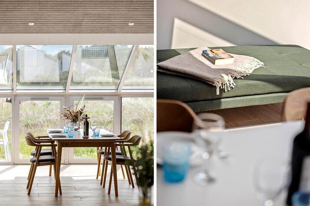 Esszimmer mit Tisch, Stühlen und großem Fenster. Grüner Sitzbank mit Decke und Buch.
