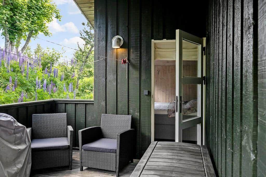 Terrasse mit zwei Sitzgelegenheiten und Blick auf Blumen.