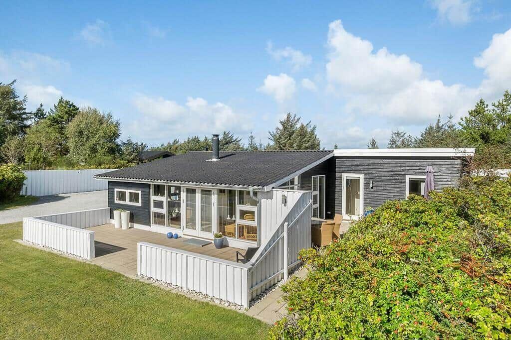 Moderne Villa mit Terrasse und Garten. Große Glasfront und Holzverkleidung.