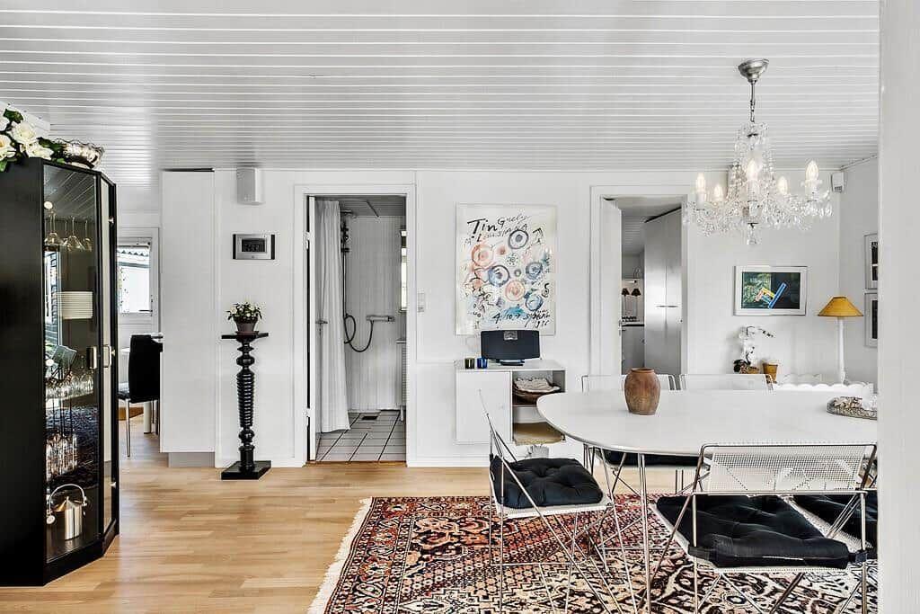 Wohn- und Essbereich mit Tisch, Stühlen, Deckenventilator und Teppich.