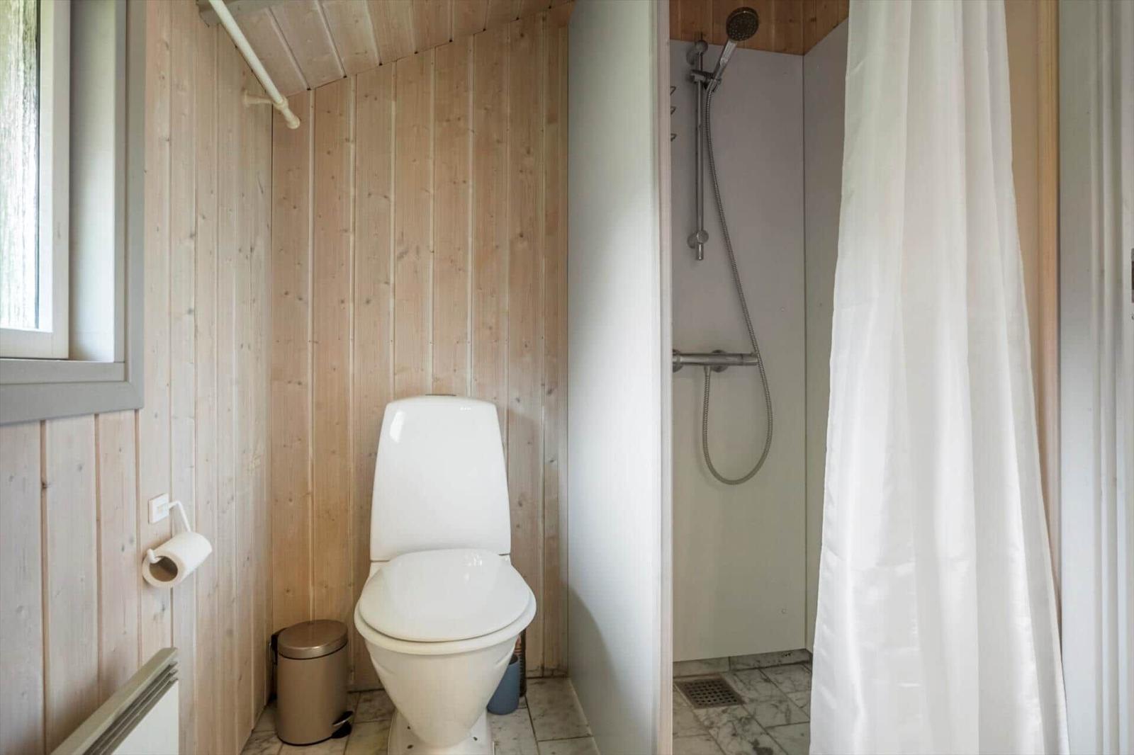 Bad mit Toilette und Dusche mit Duschvorhang