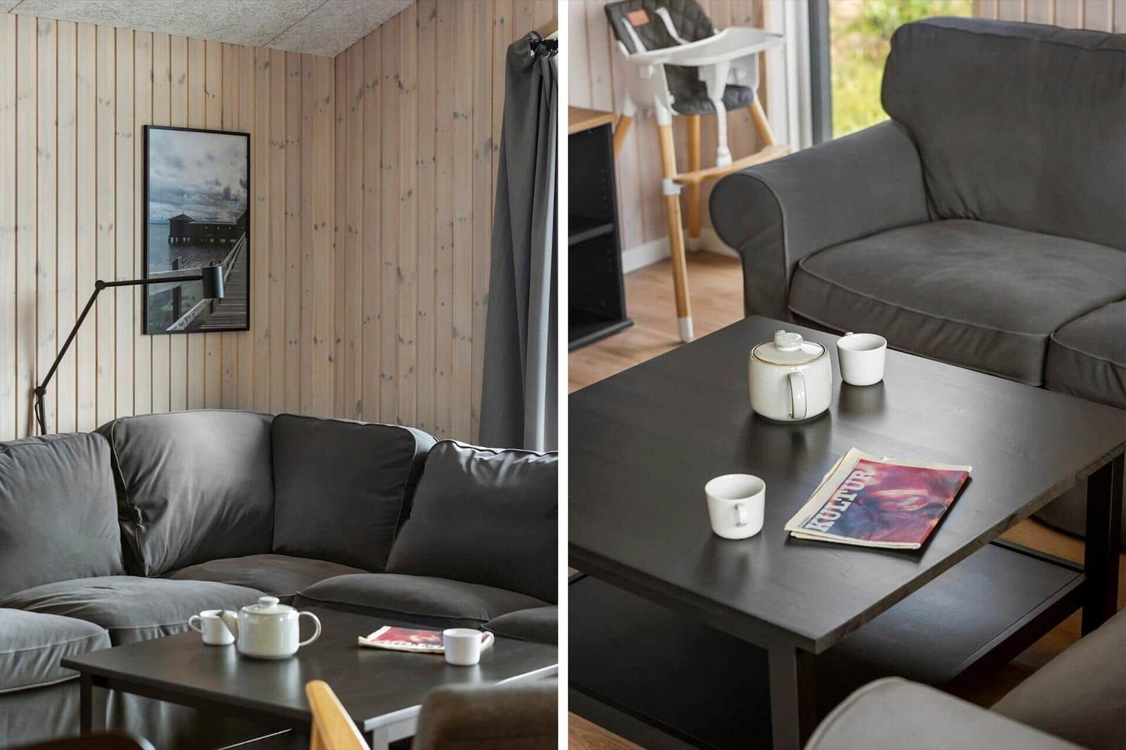 A living room with a gray sofa, wooden wall, and table with teapot and magazine.