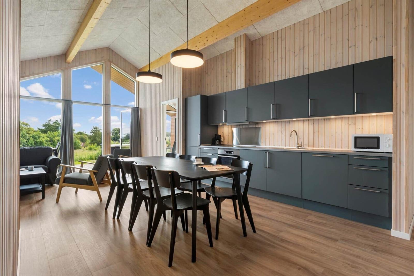 Modern kitchen with dining table and large window view of garden