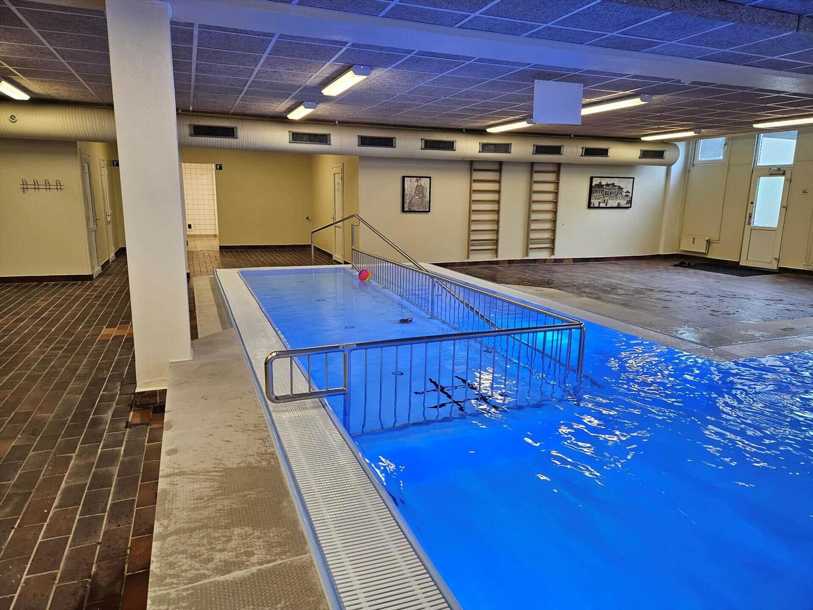 Innenpool mit Metallgeländer und Treppen zur Schwimmfläche.