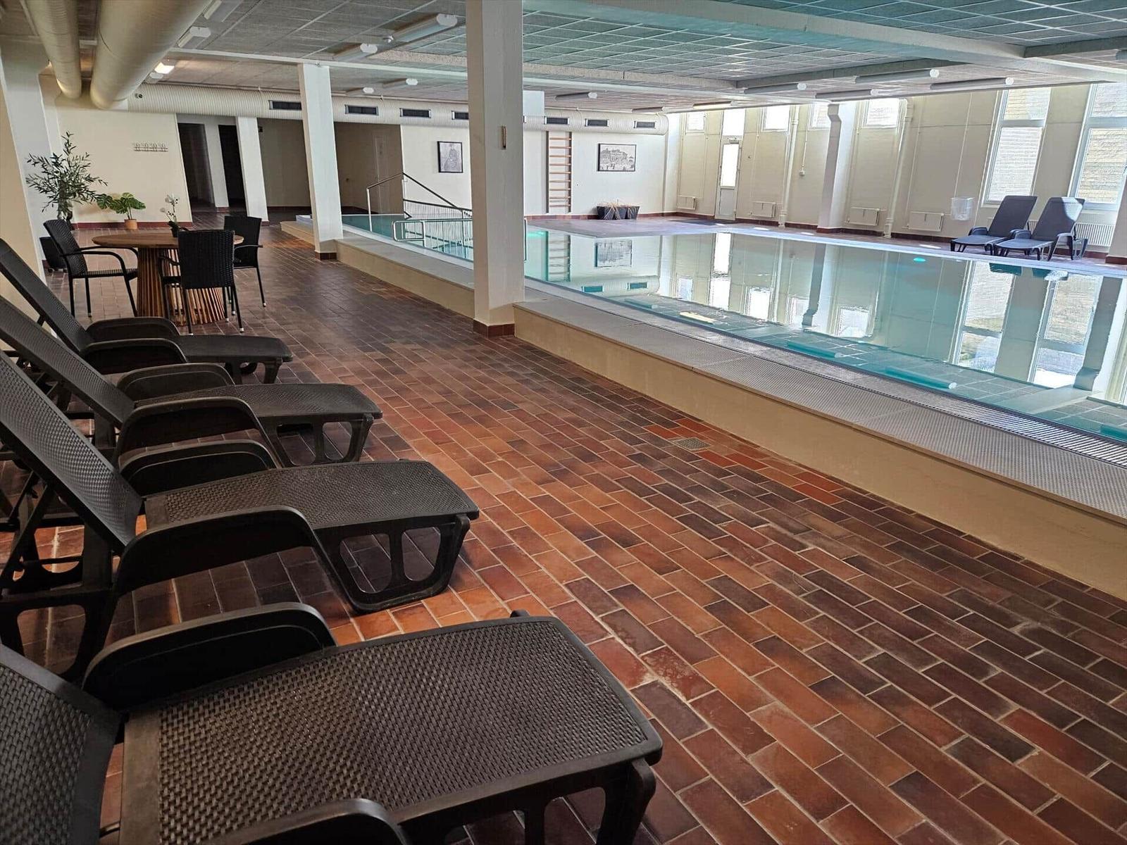 Indoorpool mit Liegestühlen und Terrasse