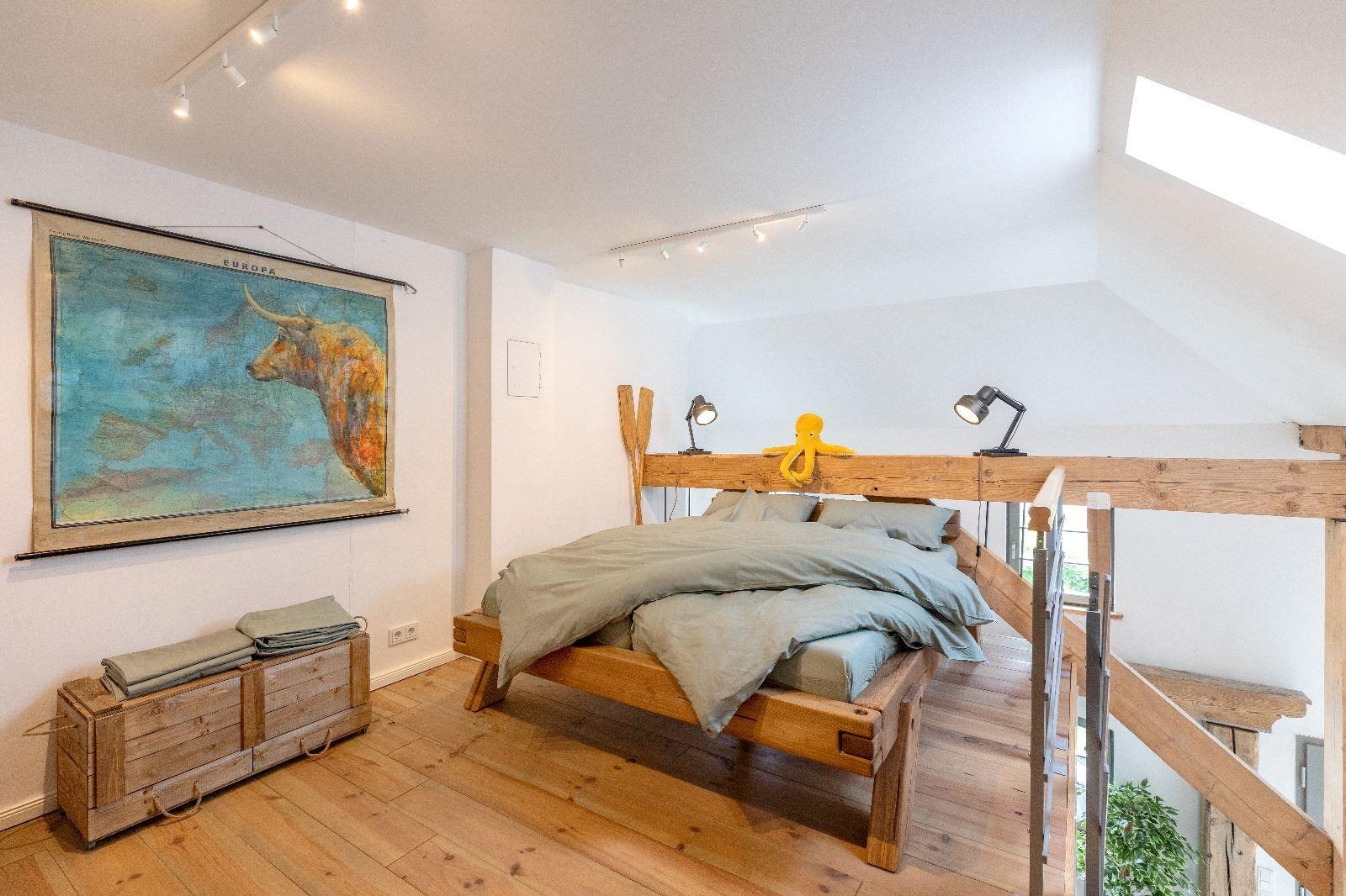 Ein Schlafzimmer mit Holzbett, Karte Europas und Holzfußboden.