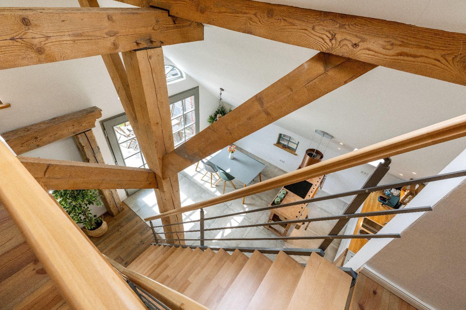 Haus mit Holzständern, Treppe und Essbereich im Erdgeschoss.