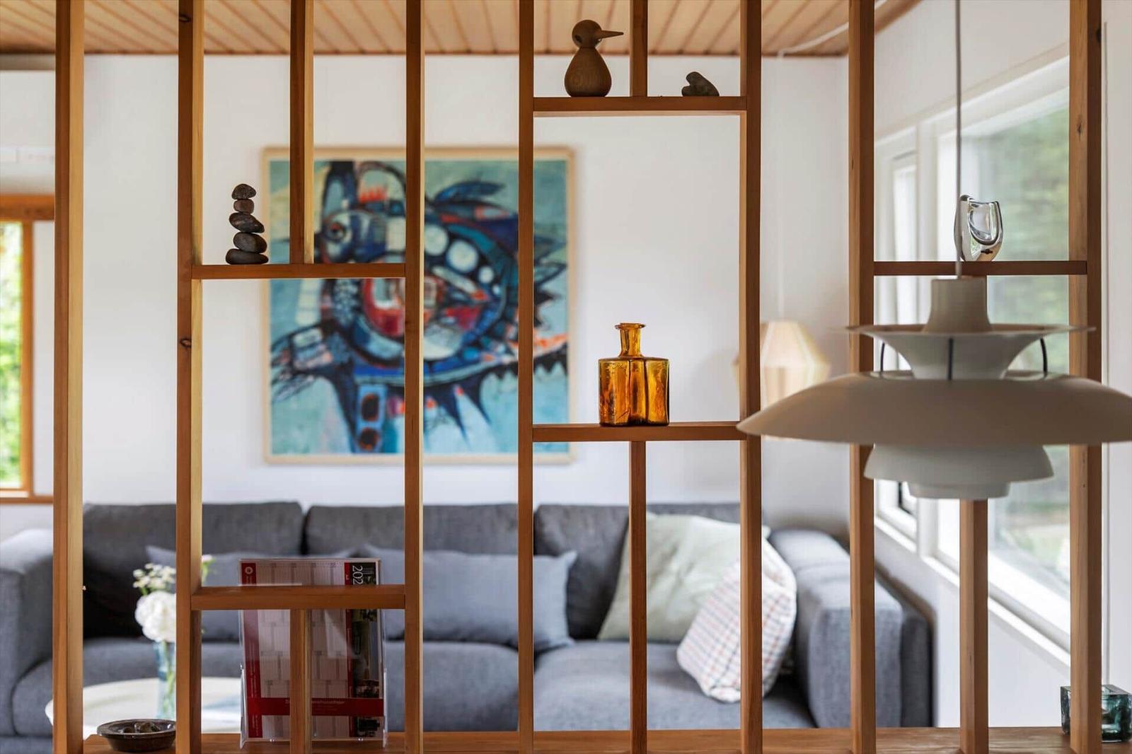 Living area with sofa, wooden shelf, and wall art