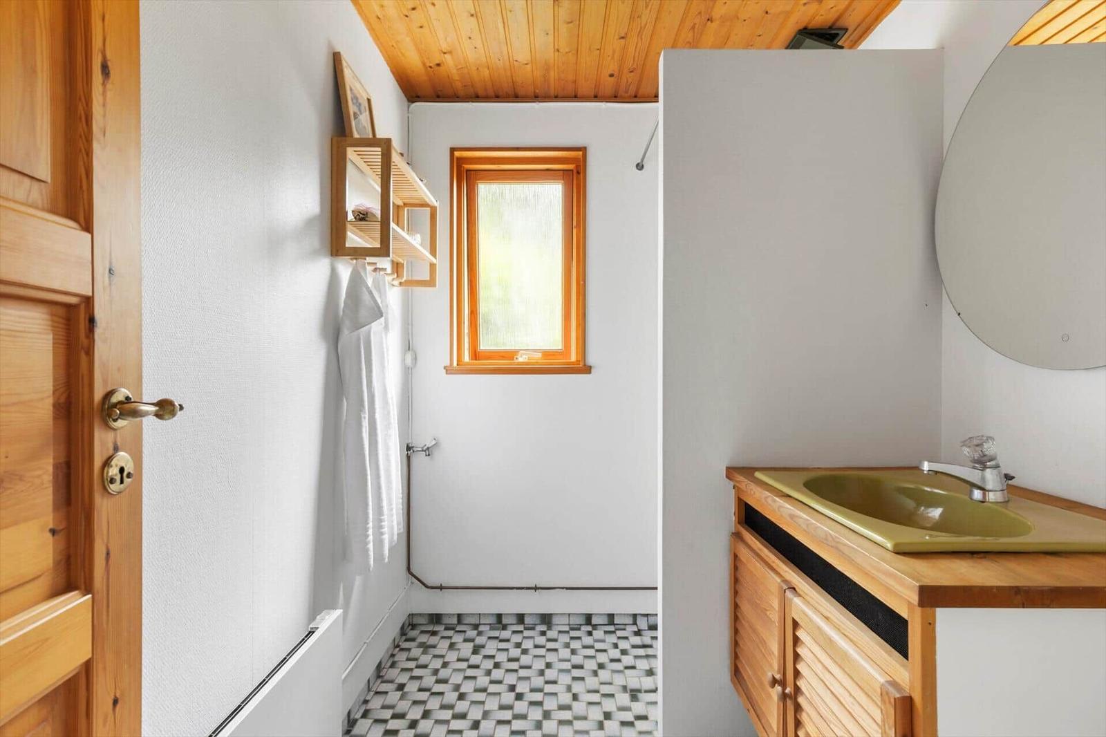Bathroom with wooden ceiling, sink, and shower.