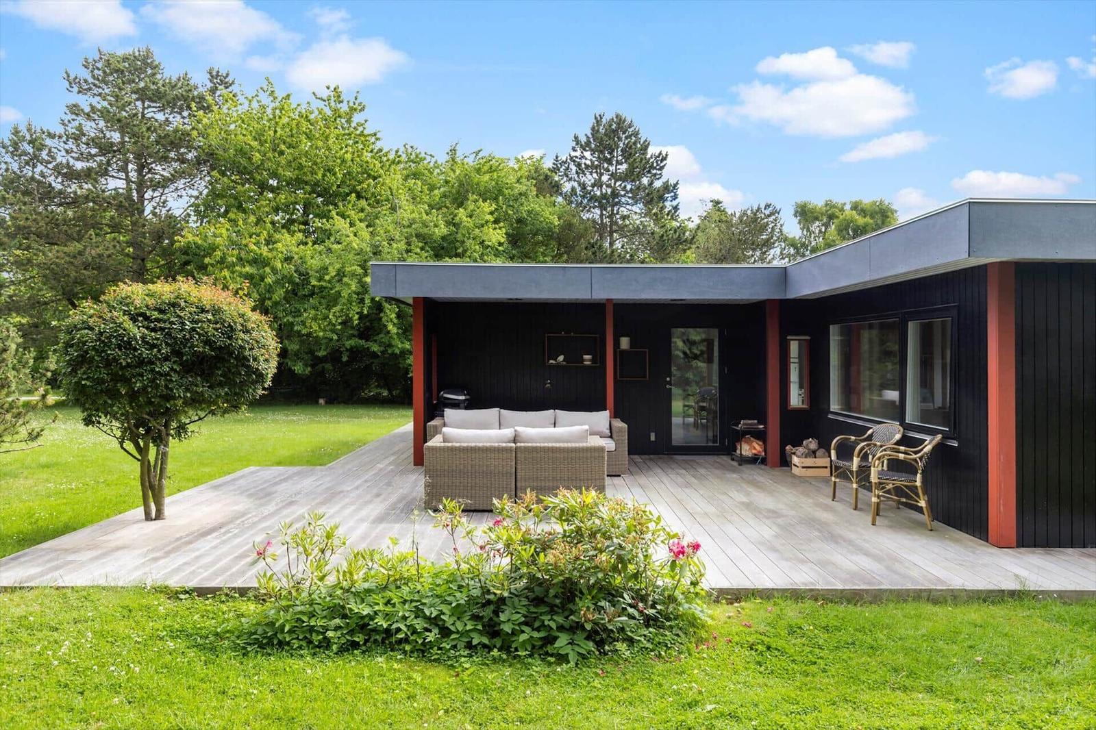Modern villa with terrace, garden, and outdoor seating.