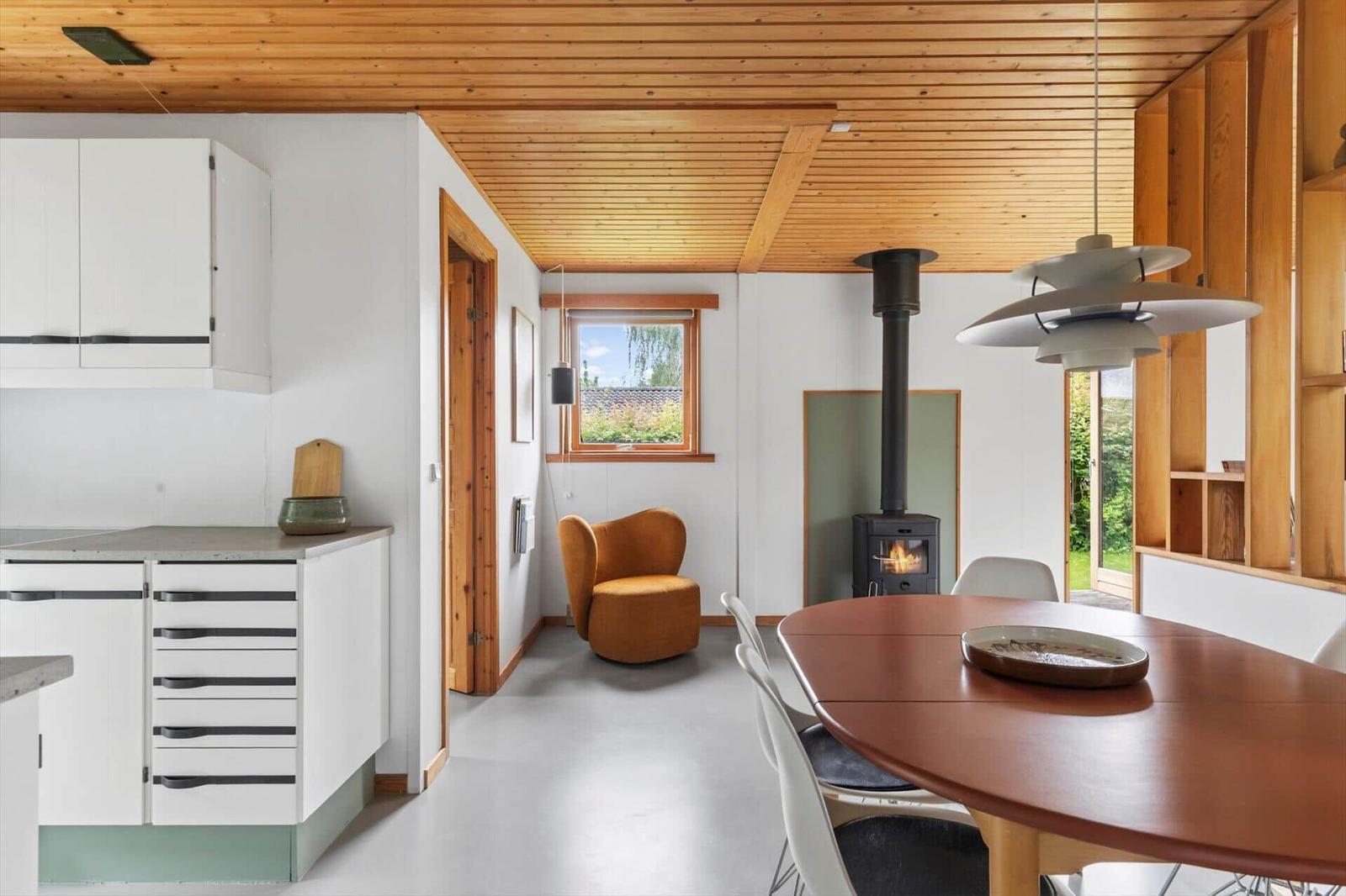 Kitchen with dining area, wooden ceiling, fireplace, and seating.