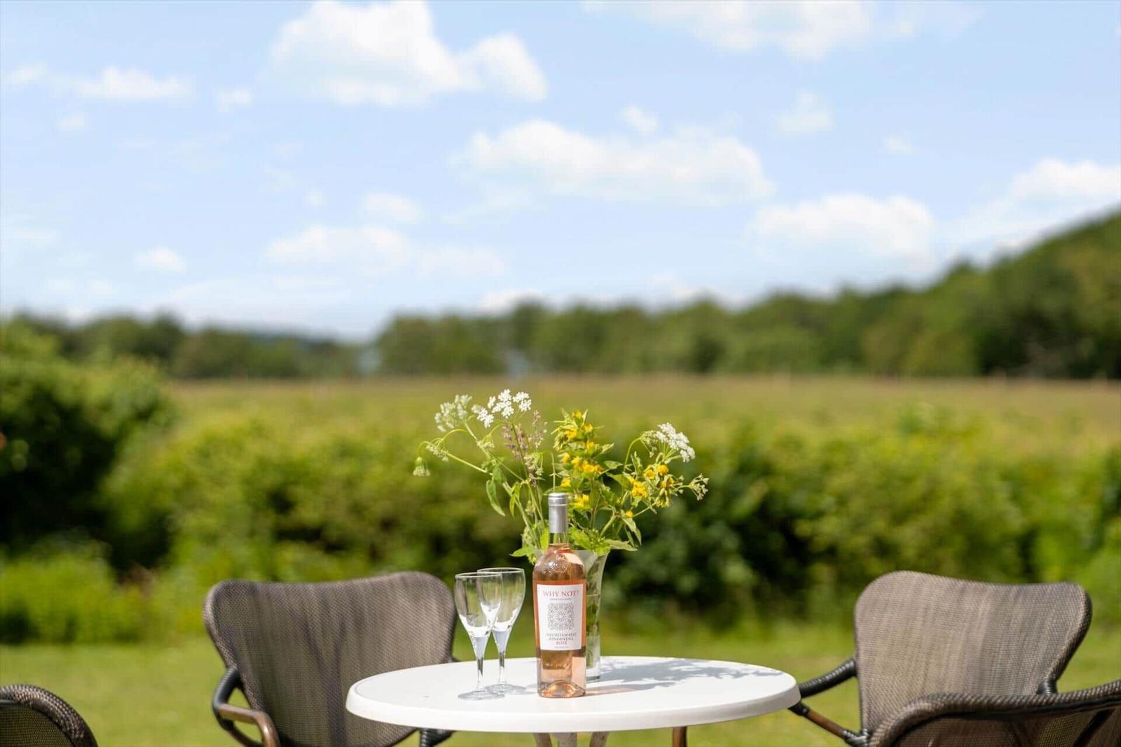 Rundtisch mit Weinflasche und Blumen im Freien