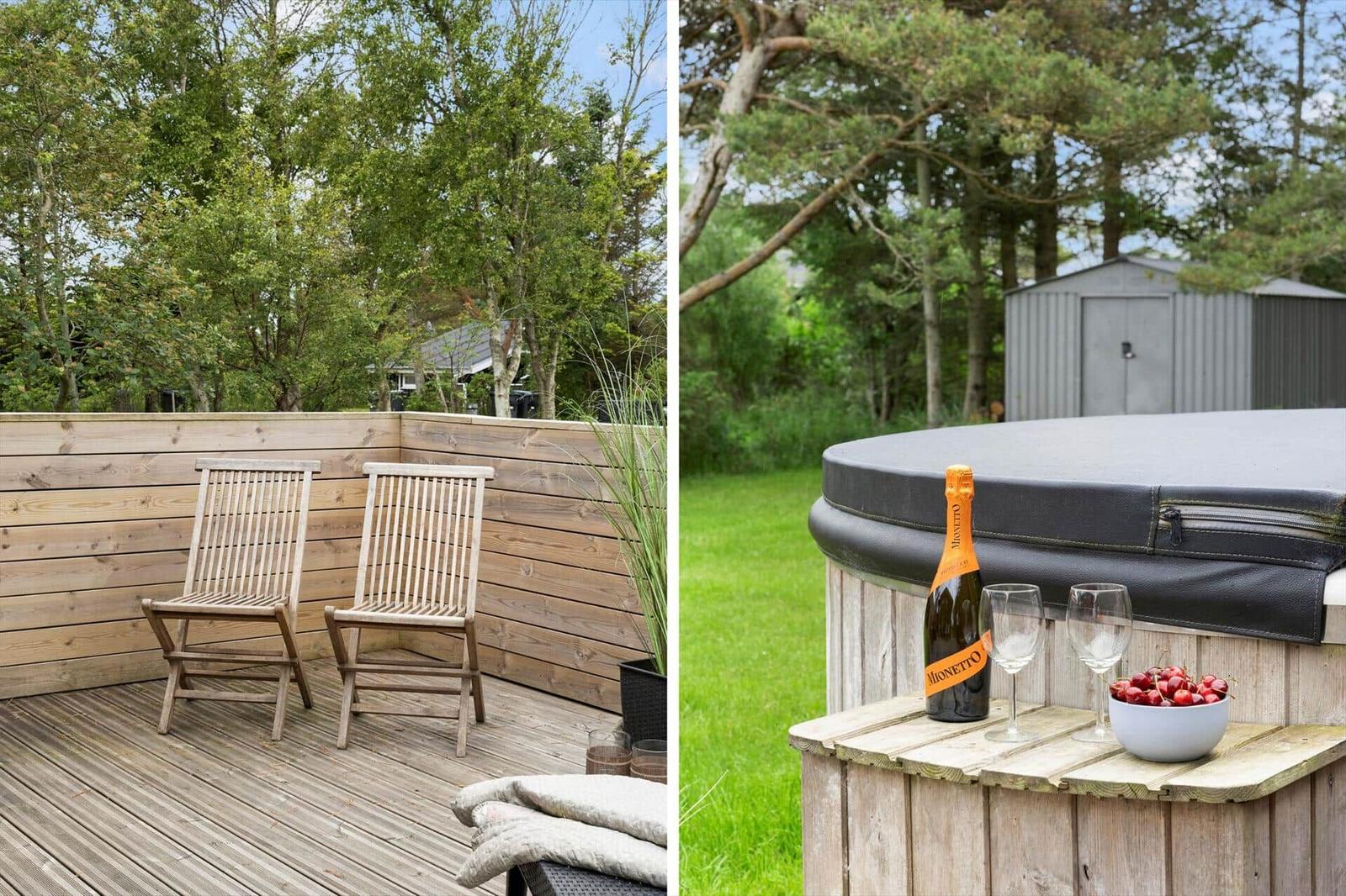 Terrasse mit zwei Holzstühlen und Blick in den Wald. Whirlpool mit Champagner und Kirschen.