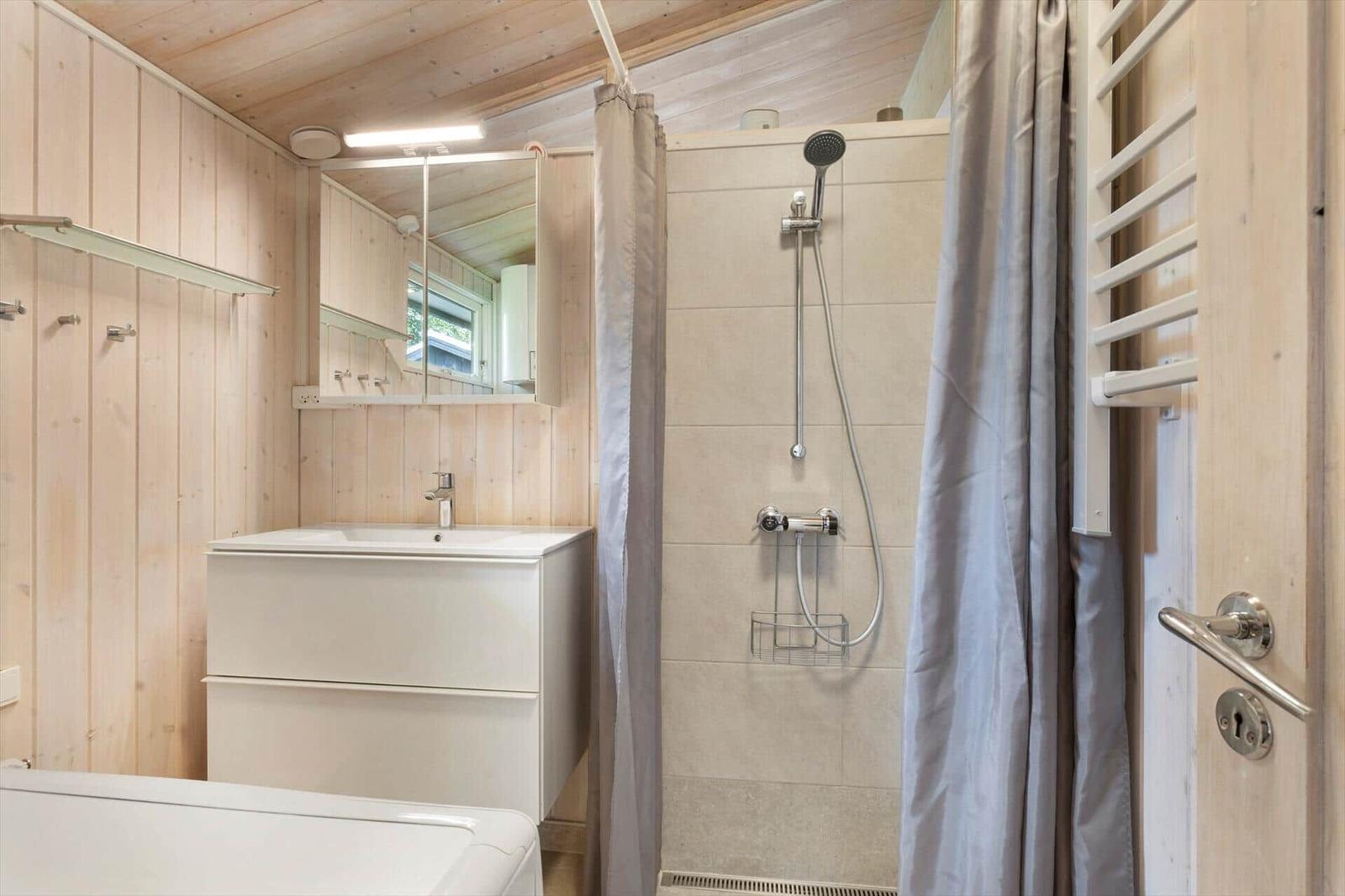 Badezimmer mit Dusche, Waschbecken und Heizung