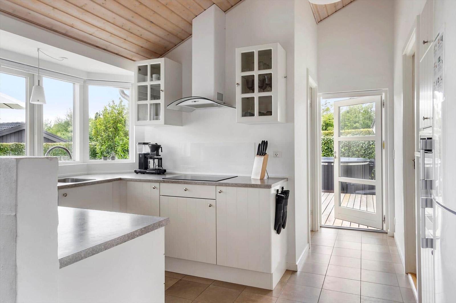 Kitchen with white cabinets, countertop, and view of terrace.