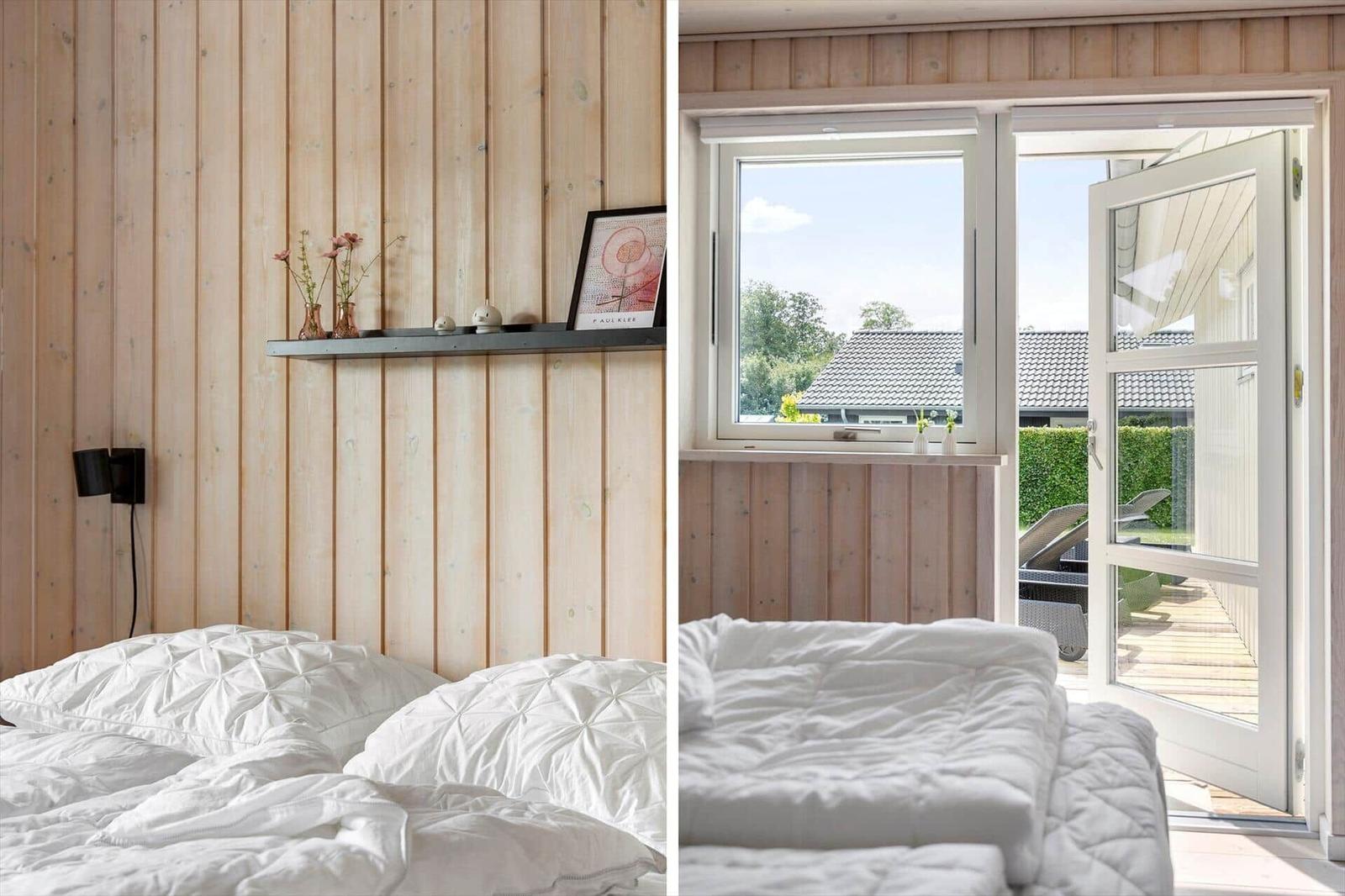 Bedroom with wooden wall and view of terrace