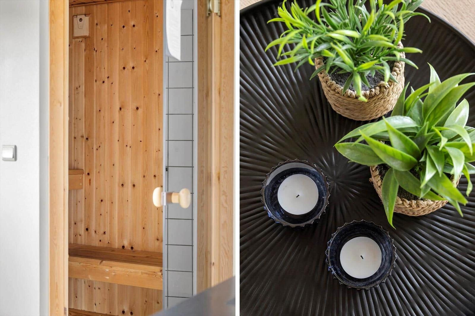 Sauna with wooden wall and bench. Table with plants and candles.